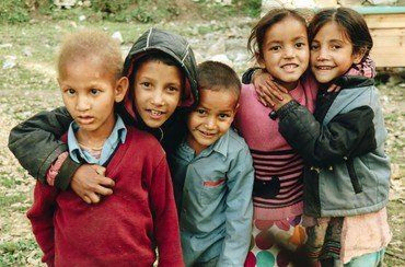 Fünf lächelnde Kinder posieren zusammen.