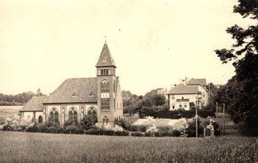 Historische Fotografie einer Kirche mit spitzem Turm.